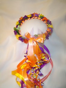 Wreath of bright orange, purple, and yellow flowers and fall leaves.