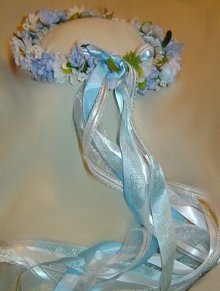 Ingrid wreath,blue and white roses and white daisies, with lacy ribbons.